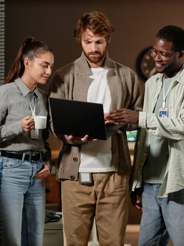 Young people using laptop in office at night