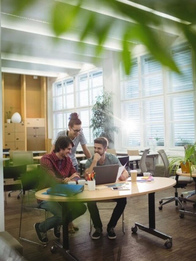 group of business executives discussing over laptop at their desk