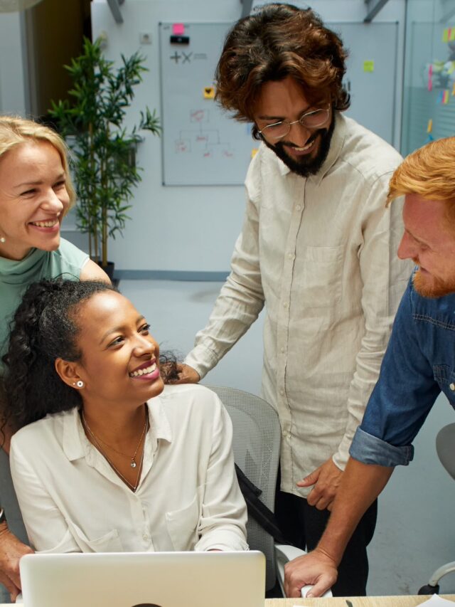 Vertical. Group of professional multirracial men and women working at office. Colleagues look happy.